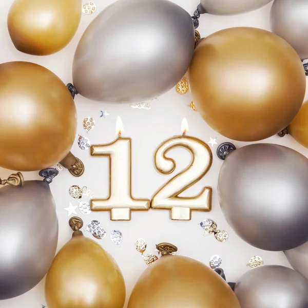 Birthday celebration number 12 candle with gold and silver ballo — Stock Photo, Image