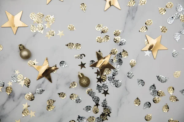 Gold star sparkle party confetti on a marble flat lay background