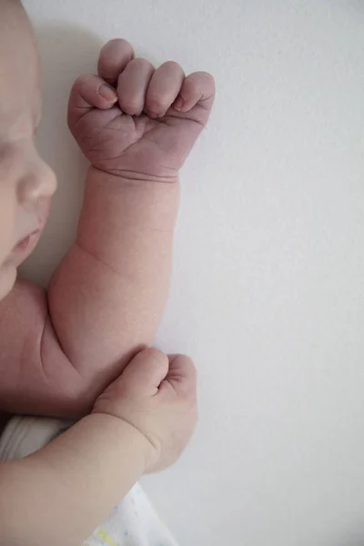Close up de um bebê adormecido bonito descansando em seus braços — Fotografia de Stock