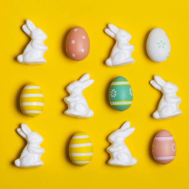 Parlak sarı arka planda Paskalya tavşanı ve yumurtalar