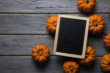 Mini balkabakları ahşap bir arka planda dizilmiş.