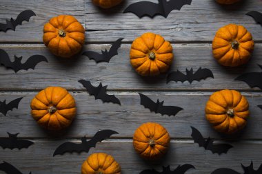 Cadılar Bayramı balkabakları ve tahta arka planda kara vampir yarasalar