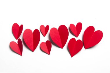 Beyaz arka planda kırmızı el yapımı kağıt kalpler.