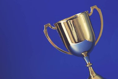 Altın ödüllü kupa mavi arka planda