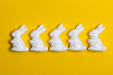 Parlak sarı arka planda Paskalya tavşanları