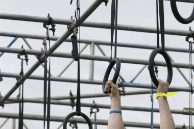 Macera engelli parkurunda yüzükler takan biri.