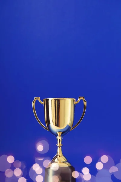Gold winners trophy cup with bokeh blurred lights — ストック写真