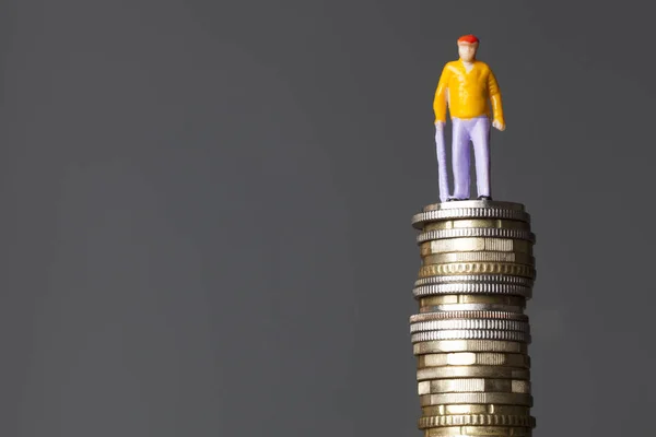 Pension concept. Old person figure on a stack of coins — Stock Photo, Image