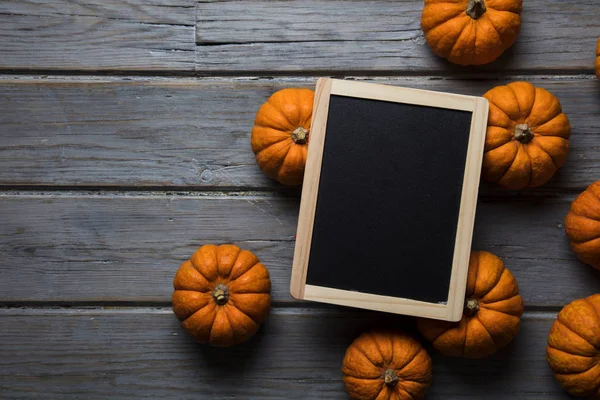 Mini balkabakları ahşap bir arka planda dizilmiş.