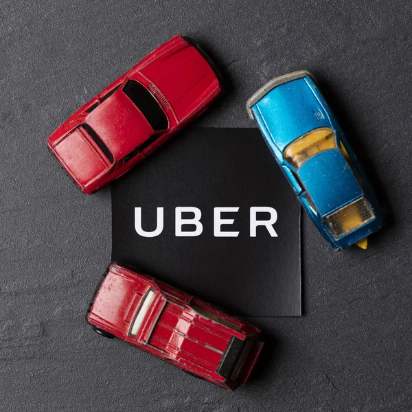 Een foto van het Uber logo en speelgoedauto. Uber is een populaire ta — Stockfoto