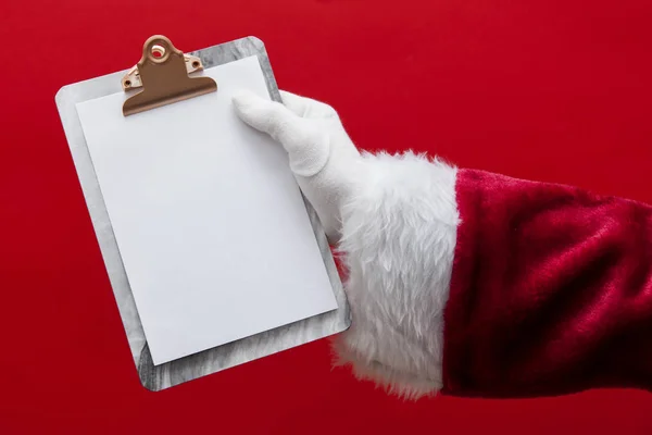 Santa Claus hand holding a clipboard with blank page — Stock Photo, Image