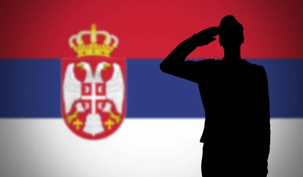 Silhueta de um soldado saudando contra a bandeira da Sérvia — Fotografia de Stock