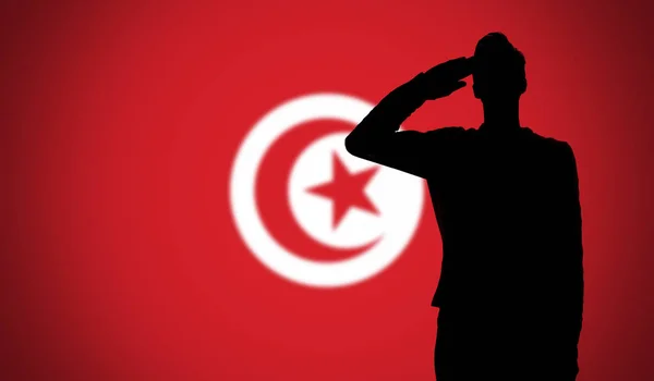 Silhueta de um soldado saudando contra a bandeira da tunisia — Fotografia de Stock