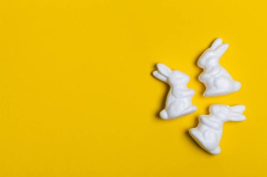 Parlak sarı arka planda Paskalya tavşanları