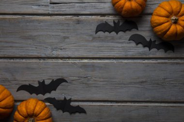 Cadılar Bayramı balkabakları ve tahta arka planda kara vampir yarasalar