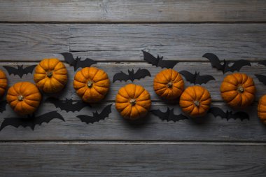 Cadılar Bayramı balkabakları ve tahta arka planda kara vampir yarasalar