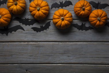 Cadılar Bayramı balkabakları ve tahta arka planda kara vampir yarasalar