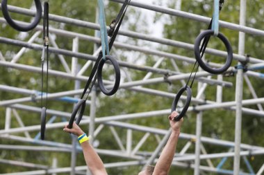 Macera engelli parkurunda yüzükler takan biri.