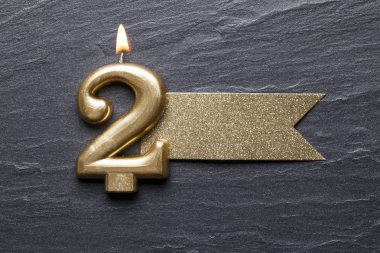 Parlak etiketli 2 numaralı altın kutlama mumu.