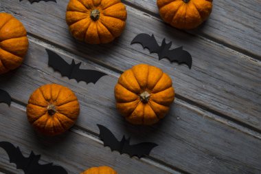 Cadılar Bayramı balkabakları ve tahta arka planda kara vampir yarasalar