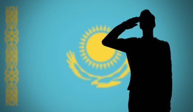 Kazakistan bayrağına selam veren bir askerin silueti.