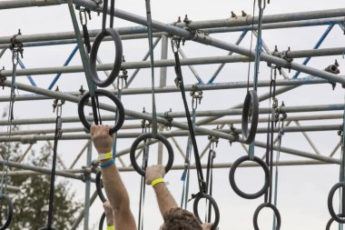 Macera engelli parkurunda yüzükler takan biri.