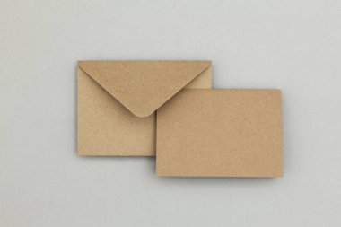 Gri arkaplanda boş kahverengi kraft kağıt ve zarf