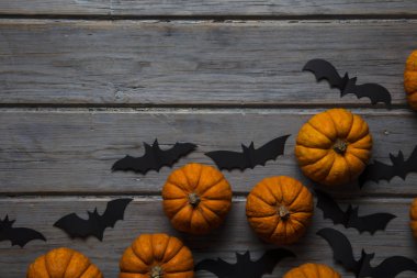 Cadılar Bayramı balkabakları ve tahta arka planda kara vampir yarasalar