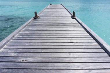 Açık mavi denizin üzerindeki ahşap iskele.