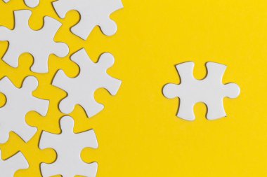 Sarı arka planda beyaz yapboz parçaları. İş solu