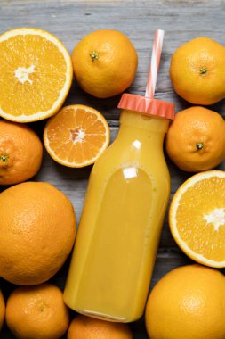 Şişe içinde taze portakal suyu. Köy ağacında portakallar var.