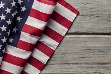 Amerikan yıldızları ve çizgileri beyaz ahşap bir döşemede bayrak sallıyor.