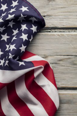 Amerikan yıldızları ve çizgileri beyaz ahşap bir döşemede bayrak sallıyor.