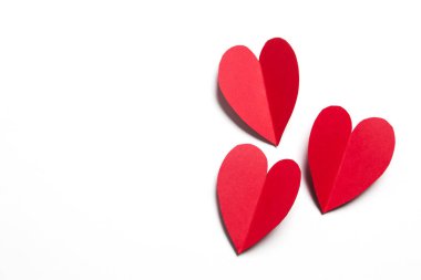 Beyaz arka planda kırmızı el yapımı kağıt kalpler.