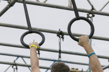 Macera engelli parkurunda yüzükler takan biri.