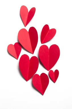 Beyaz arka planda kırmızı el yapımı kağıt kalpler.