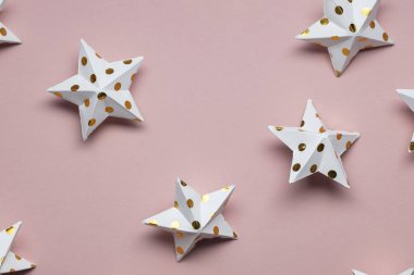 Pastel pembe üzerine beyaz ve altın yıldız süslemeleri. Mevsimlik fetiş
