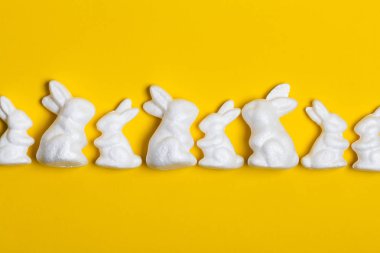 Parlak sarı arka planda Paskalya tavşanları