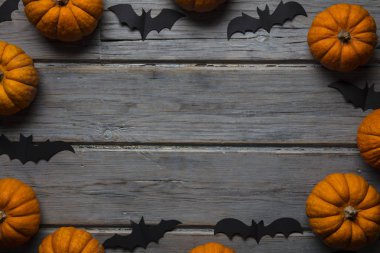 Cadılar Bayramı balkabakları ve tahta arka planda kara vampir yarasalar