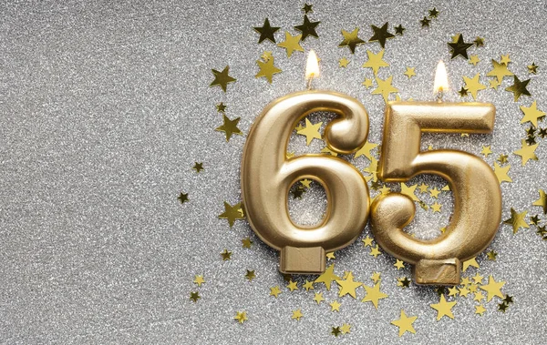 Number 65 gold celebration candle on star and glitter background — Stock Photo, Image