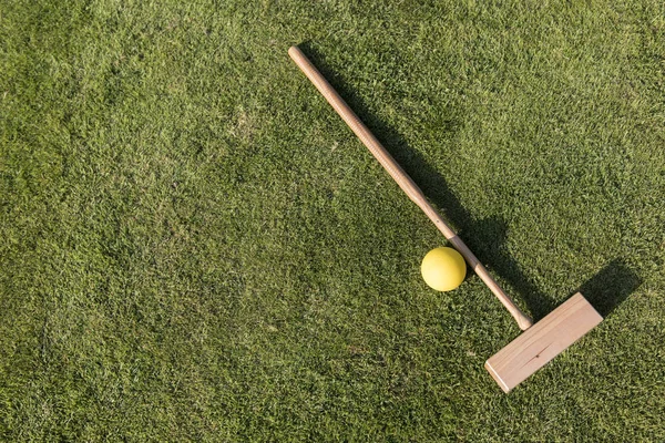 Croquet mallet and ball on a green lawn in summer — Stock Photo, Image