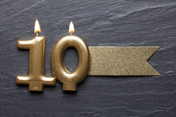 Guld nummer 10 firande ljus med glitter etikett — Stockfoto