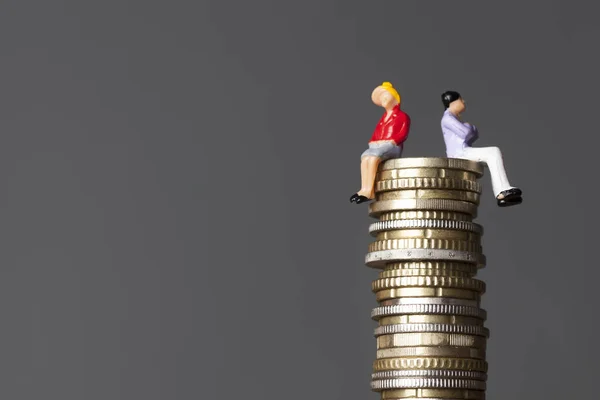 Gênero pagar conceito de igualdade. homem e mulher em uma pilha de moedas . — Fotografia de Stock