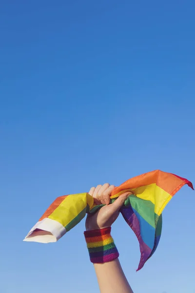 Concetto di orgoglio gay. mano tenendo un gay orgoglio LGBT arcobaleno bandiera . — Foto Stock