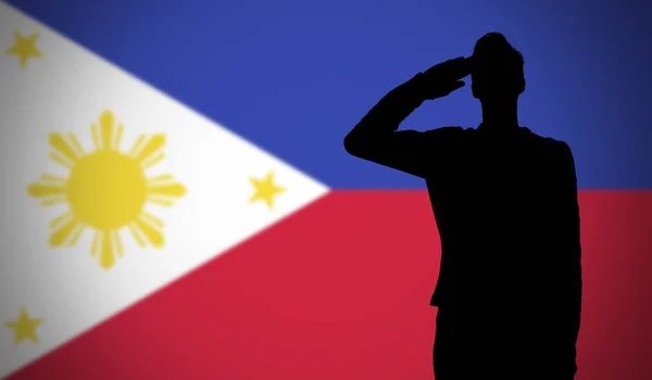 Filipinler bayrağına selam veren bir askerin silueti — Stok fotoğraf