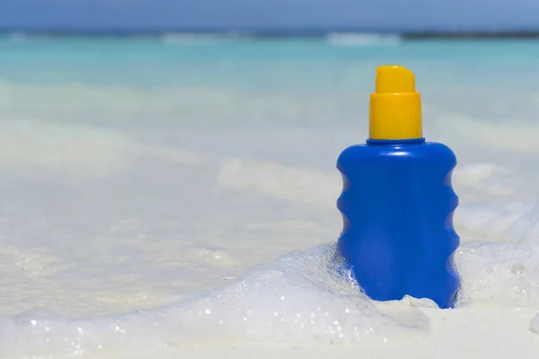 Bottle of sun lotion suncream protection on a tropical beach