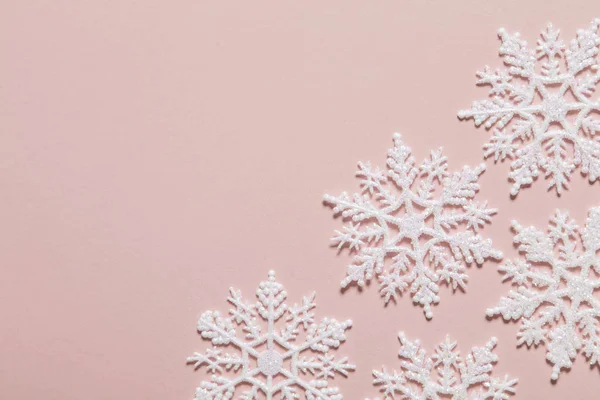 Bílé třpytky sněhové vločky složení na pastelově růžové pozadí — Stock fotografie