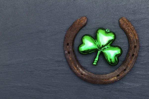 Lucky horse shoe with St Patrick 's day green clover decorations — стоковое фото