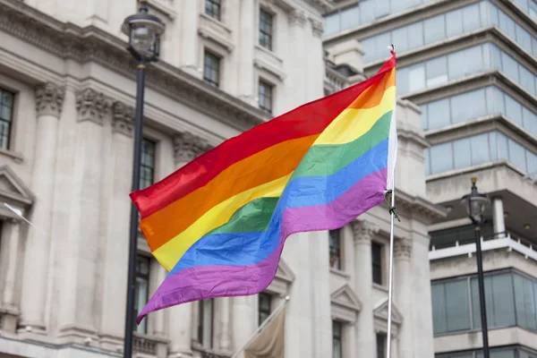 Gay rainbow flag being waved at an LGBT gay pride march in Londo — Stock Photo, Image