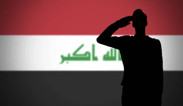 Sylwetka żołnierza salutującego przeciwko fladze Iraku — Zdjęcie stockowe